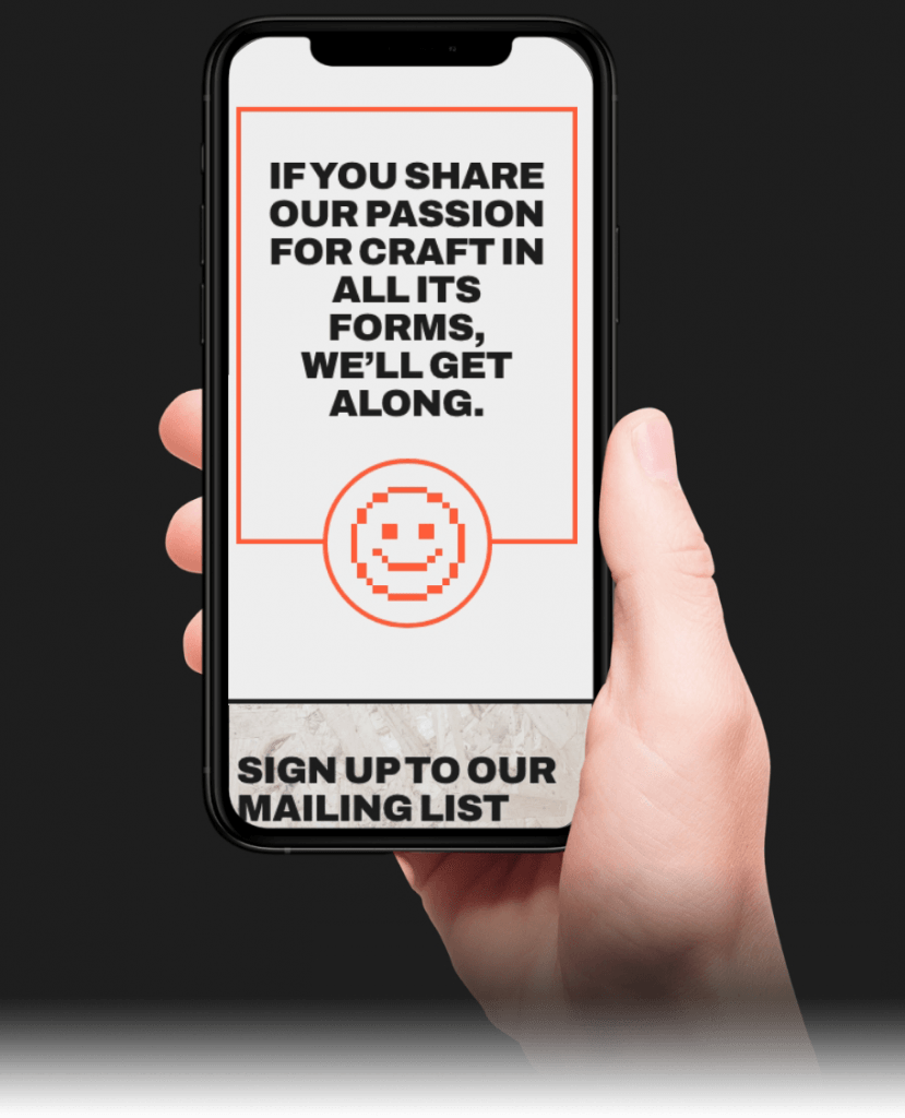 Caucasian hand holding a black smartphone showing the 1000 Trades website's takeaway page